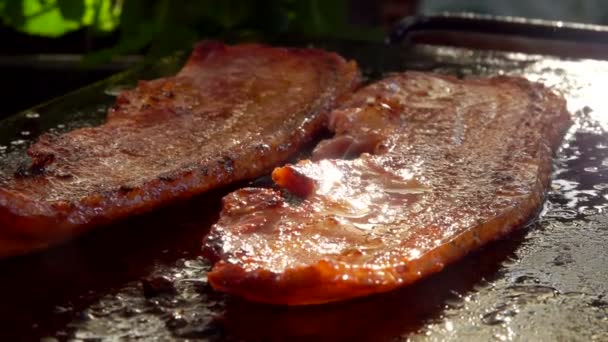 Two strips of raw bacon are roasted of the grill - Imágenes, Vídeo