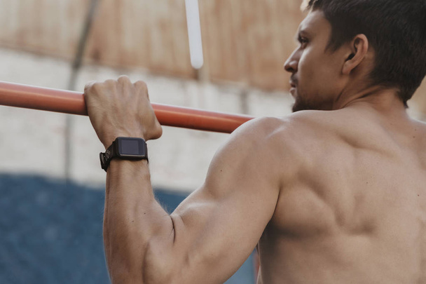 Close up of athlete practicing calisthenics with smartwatch on h - Photo, Image