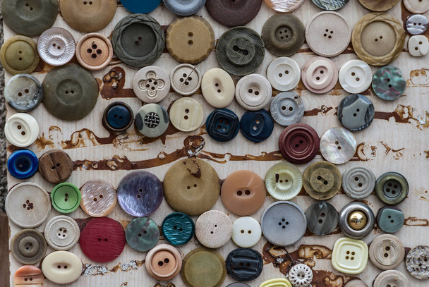 壁のディスプレイ上の衣類のボタンの様々な - 写真・画像