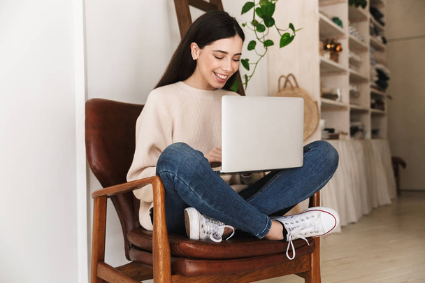 Photo of pretty smart woman 20s working on laptop computer while - Zdjęcie, obraz
