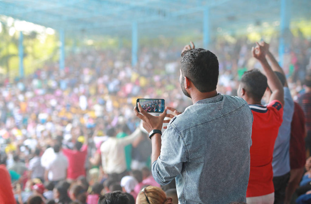 Posluchačům se nabízí zábava s fotografem na hudebním festivalu na stadionu. Zadní pohled. - Fotografie, Obrázek