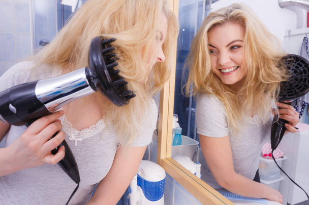 Woman doing curls with hairdryer diffuser - Valokuva, kuva
