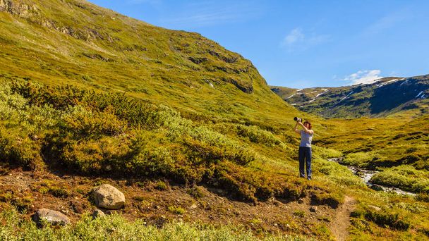 Tourist taking photo in norwegian nature - Φωτογραφία, εικόνα