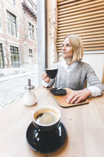 vrouw drinken koffie in een café - Foto, afbeelding