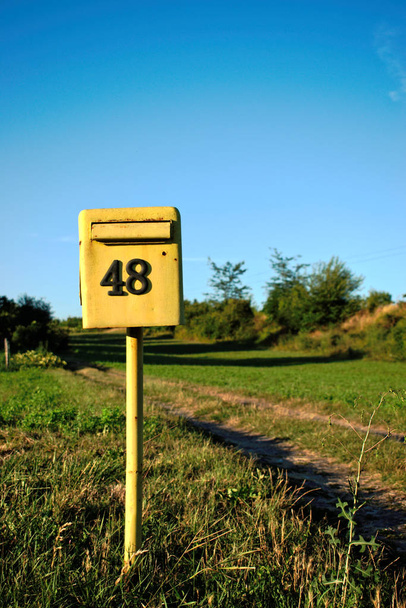 Κίτρινο γραμματοκιβώτιο νούμερο 48 σε ανοιχτό χώρο - Φωτογραφία, εικόνα