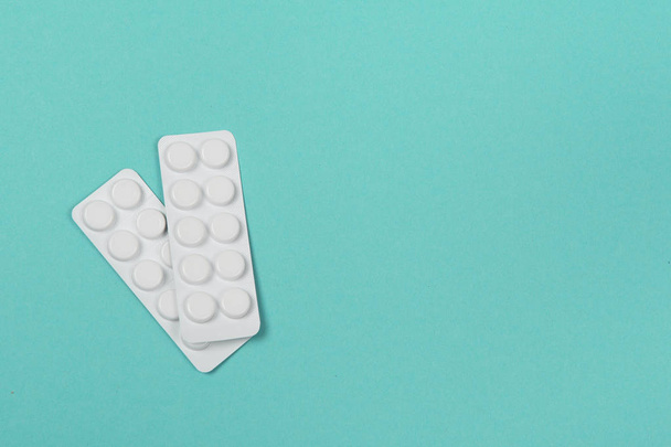 Dos tiras de tabletas de medicamentos sobre un fondo azul
 - Foto, Imagen