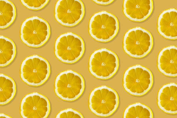 Tvůrčí vzorek vyrobený z citrónu. pohled na čerstvé citrusové řezy na barevném žlutém & oranžovém pozadí.  - Fotografie, Obrázek