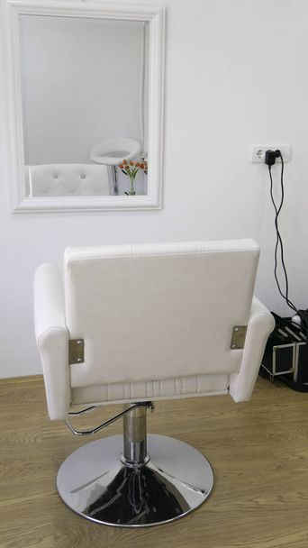 Λευκή καρέκλα κομμωτικής μπροστά από τον καθρέφτη  - Φωτογραφία, εικόνα