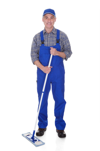 Mature Man Cleaning Floor With Mop - 写真・画像