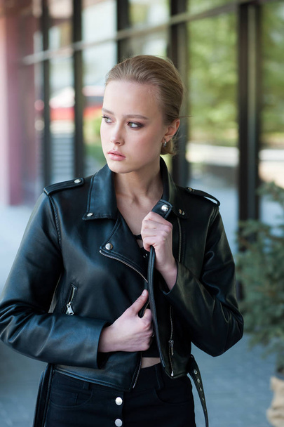Beautiful young blonde woman in black leather jacket portrait - Foto, afbeelding