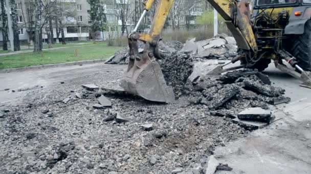 Wiadro ciągnika łamie asfalt - Materiał filmowy, wideo