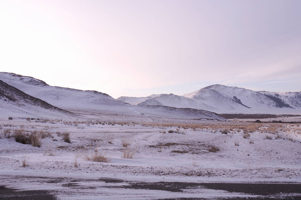 frühmorgendlicher Sonnenaufgang in der tazran-Steppe. Die schneebedeckten Hügel sind in Ultravioletttönen gefärbt. Foto abgeschwächt. - Foto, Bild