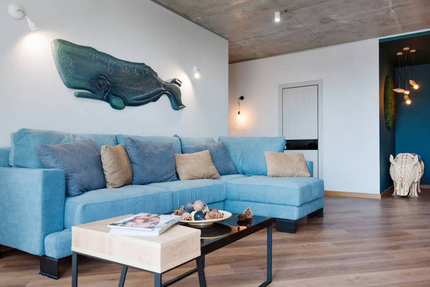 Сучасна мінімалістська вітальня з диваном в стилі лофт плоска. Сучасна лофт-студія з вітальнею, інтер'єр відкритого простору в скандинавському стилі з меблями. Справжнє фото - Фото, зображення