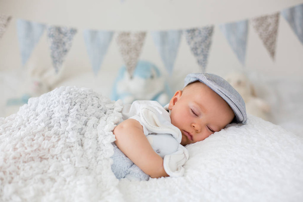 Sweet little child, baby boy, sleeping in a sunny bedroom during - Foto, afbeelding