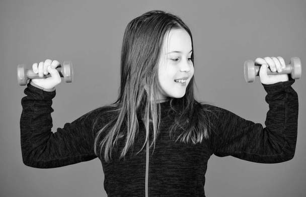 Feeling energy inside. Happy child with barbell. Fitness for energy health. workout of small girl hold dumbbell. weight lifting for muscules. Sport success. full of energy. Young and full of energy - Fotografie, Obrázek
