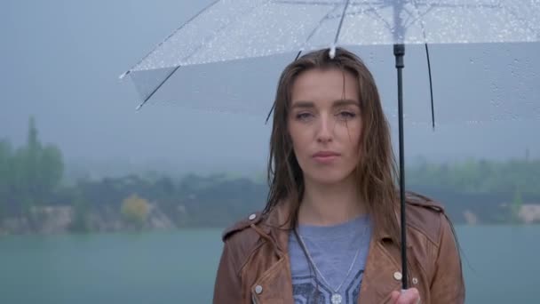 Πορτρέτο του νεαρού όμορφο κορίτσι κάτω από μια ομπρέλα στο βροχερό - Πλάνα, βίντεο