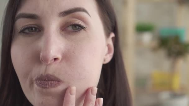 Close up young woman disguises makeup rosacea on face - Materiał filmowy, wideo