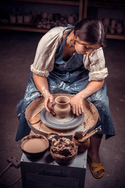 スタイリッシュな手工芸師の職人が陶器を作り、車輪の上の濡れた粘土から彫刻家。職人プロダクション. - 写真・画像