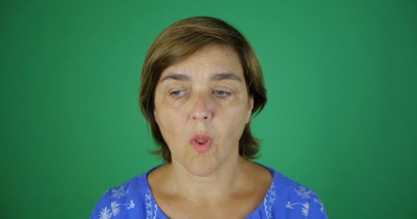 An adult woman is surprised by something and puts her hands to her chin while - Footage, Video