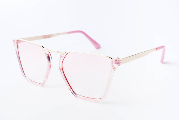 Gafas de sol con lente rosa sobre fondo blanco
 - Foto, Imagen