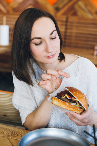 Woman eating a freshly prepared delicious Burger  - Fotoğraf, Görsel