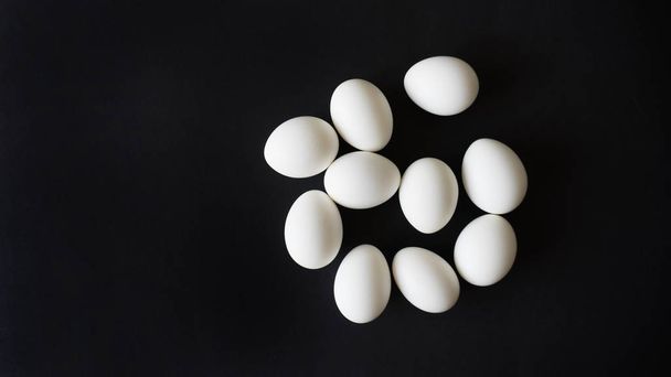 chicken egg lies on a black isolated background top view - Foto, Bild