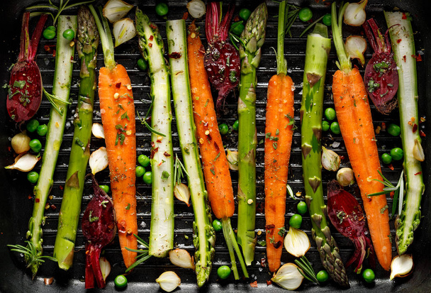 Grilling vegetables, raw vegetables prepared for grilling with the addition of olive oil, herbs and spices located on the grill plate. Healthy nutrition concept, vegan meal - Photo, Image