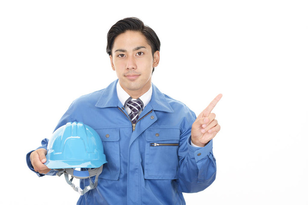 Aziatische werknemer wijzen geïsoleerd op witte achtergrond - Foto, afbeelding