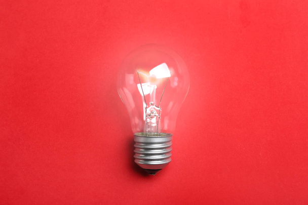 New modern lamp bulb on color background, top view - Foto, imagen