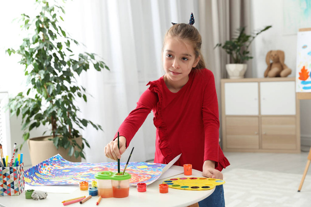 Little child painting picture at table indoors - Foto, Imagem