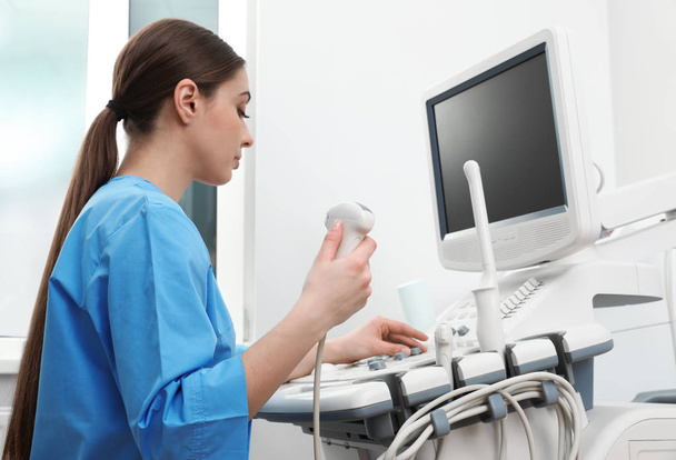 Sonographer operating modern ultrasound machine in clinic - Foto, immagini