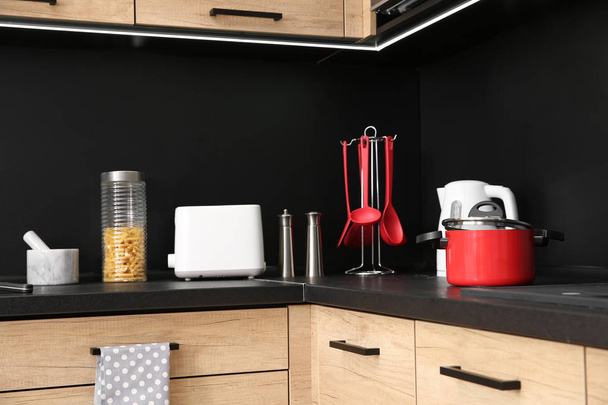 Interior da cozinha com mobiliário novo, eletrodomésticos e utensílios domésticos
 - Foto, Imagem