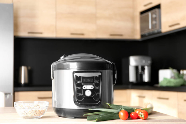 Modern multi cooker and ingredients on table in kitchen - Foto, immagini