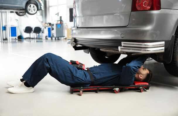 Technician checking modern car at automobile repair shop - Zdjęcie, obraz
