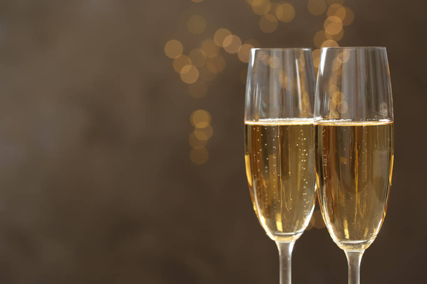 Glasses of champagne against blurred lights, closeup. Space for text - Fotoğraf, Görsel