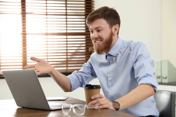 Man using video chat on laptop in home office - Fotoğraf, Görsel