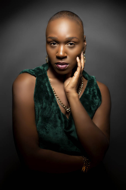 Black African American female fashion model with a bald hairstyle in a studio.  The portrait shows the beauty and confidence of the bold and trendy glamour hairdo style.   - Foto, Imagem