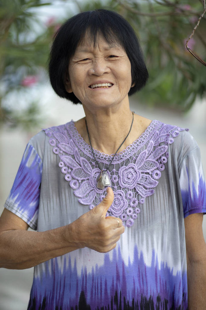 Лицо азиатской пожилой женщины, смеющейся от эмоций счастья
 - Фото, изображение
