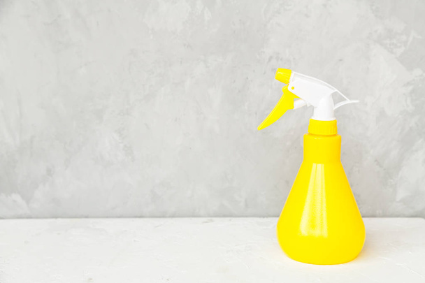 Simple yellow plastic hand spray bottle on gray background. - Zdjęcie, obraz