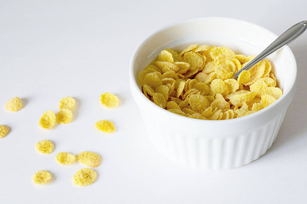 Beyaz arka plan üzerinde mısır gevreği ve süt ile sağlıklı kahvaltı - Fotoğraf, Görsel