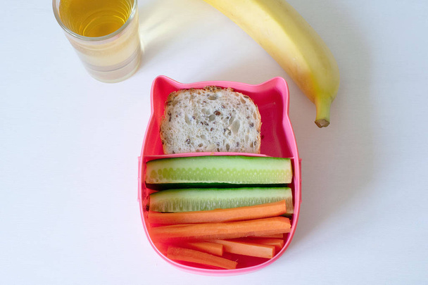 Healthy lunch boxes with sandwich, fresh vegetables and fruits on white wooden background - Photo, Image