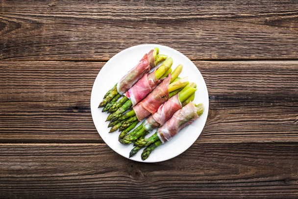Cooked asparagus with ham. Appetizer with vegetable and meat, paleo food concept - Φωτογραφία, εικόνα