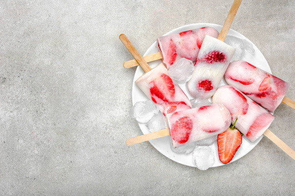 Fresh strawberry popsicles. Fruit food snack on plate. - Foto, Imagen