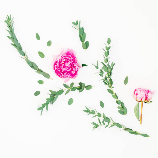 Floral composition of pink peony flower and eucalyptus branches with leaves on white background. Flat lay, top view - Foto, afbeelding