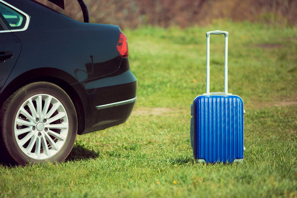 View of modern black car and suitcase on the rivers side - Foto, afbeelding