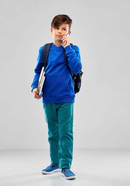 studente ragazzo con scuola borsa chiamata su smartphone
 - Foto, immagini