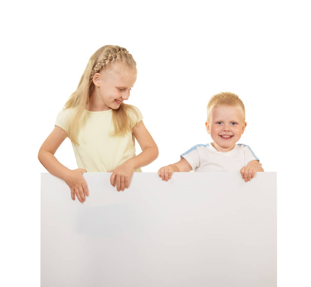 Little boy and girl smiling and holding blank banner isolated on white background - Foto, Bild