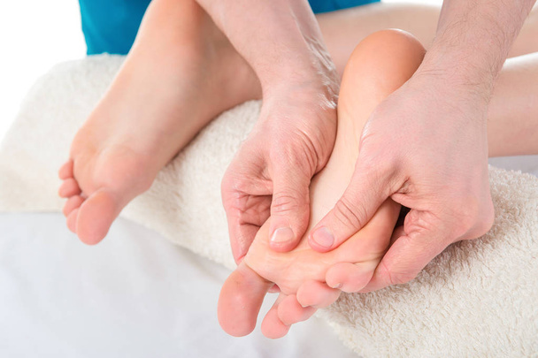 Mãos de homem dando massagem para pés nus macios
 - Foto, Imagem