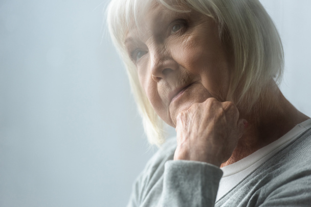 selective focus of pensive senior woman with grey hair propping face with hand - Photo, Image