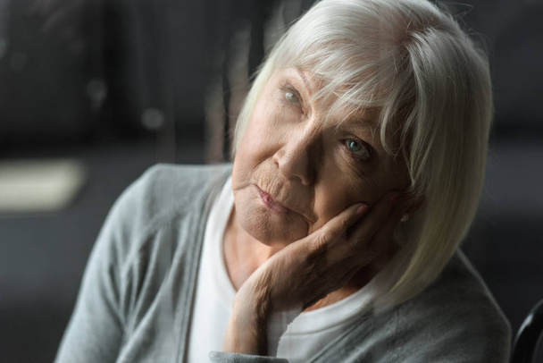 selective focus of pensive senior woman with grey hair propping face with hand - Foto, Imagen